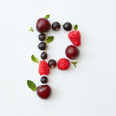Berries pattern of letter P english alphabet from natural ripe berries - black currant, cherries, raspberry, mint leaf isolated on a white background.