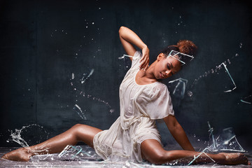 Young afro girl posing over water and glass.