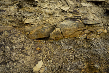 Soil cut-sandstone, stones, clay, sand structure and layers. slice of sand with layers of different structures.