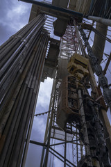 Oil and Gas Drilling Rig onshore dessert with dramatic cloudscape. Oil drilling rig operation on the oil platform in oil and gas industry.