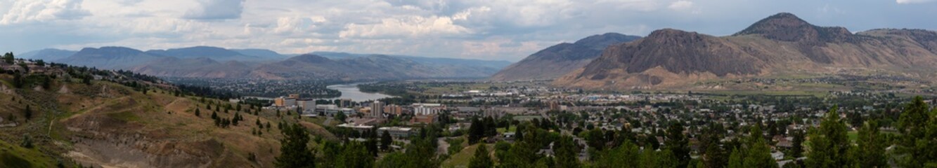 Fototapeta na wymiar Aerial panoramic view of Kamloops City during a cloudy summer day. Located in Interior BC, Canada.
