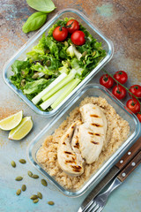 Healthy meal prep containers with quinoa, chicken breast and green salad overhead shot. Top view. Flat lay
