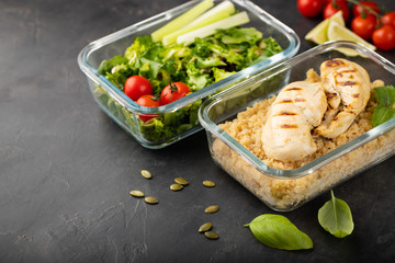 Healthy meal prep containers with quinoa, chicken breast and green salad overhead shot with copy space