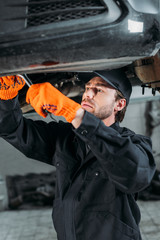 male mechanic repairing a car in auto repair shop