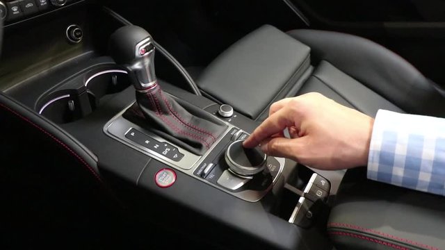 Hand operating luxury car console first pearson view from driver side