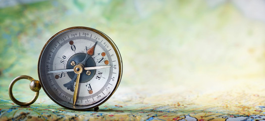 Magnetic old compass on world map.Travel, geography, navigation, tourism and exploration concept background. Macro photo. Very shallow focus.