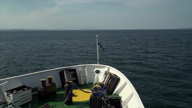 Wide-shot from boat over looking the bow of the ship, with sea, and amazing clear skies.