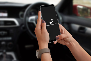 Woman connecting car with her smartphone and app using wifi