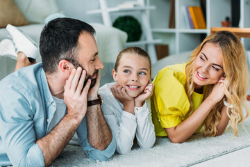 Obraz premium happy young family lying on floor at home together