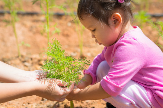 Mother teaching her child how to care for plants - Powered by Adobe