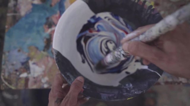 Overhead shot of an artist mixing colors with white paint