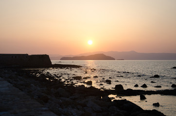 Beautiful sunset over mountains near sea. Sunset and red orange sky over mountain in Greece, Chania. Mediterranean Sea