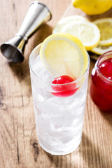 Classic Tom Collins cocktail on wooden table. 