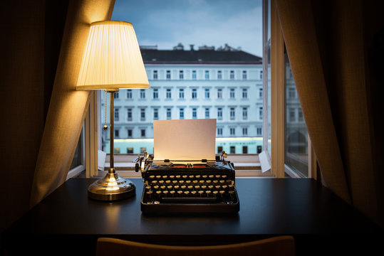 Workplace of a writer, journalist, creator. An old typewriter and a lamp on the table. Retro style. The concept on scientific, historical, literature, education and philosophical topics.