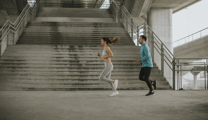 Young couple running in urban enviroment