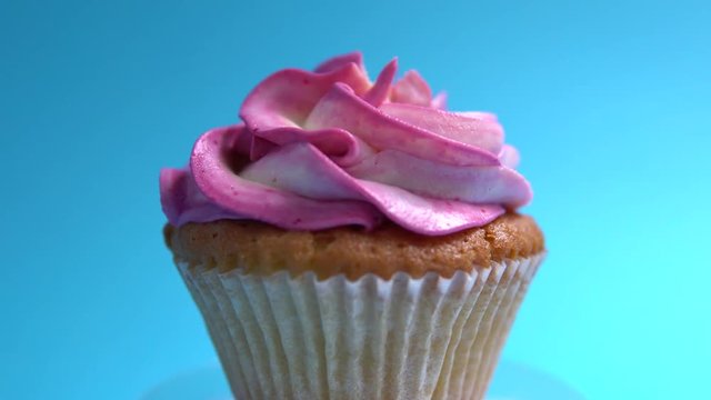 A delicious and appetizing capcake rotates against a blue background.