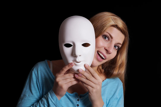 young woman removing plain white mask from her face