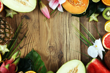Assortment of tropical fruits with leaves of palm trees and exotic plants