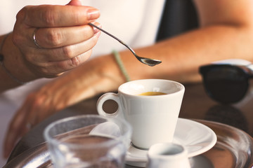 Woman drinking hot coffee in outdoor cafe