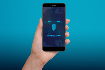 Female scanning fingerprint on smartphone, on bright blue background. Modern identification and security concept