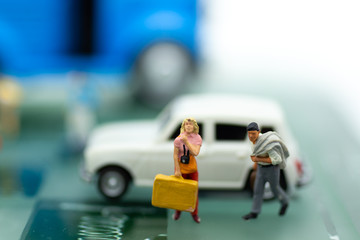 miniature people, backpack waiting bus at bus station for travel. using as business background concept.
