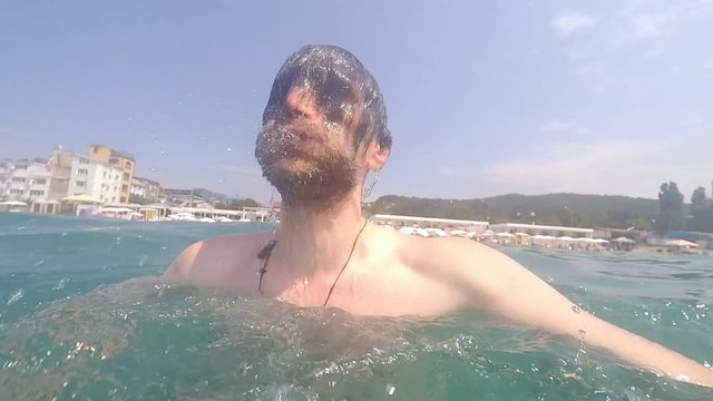 POV of man with beard swimming in sea water on sunny day Summertime