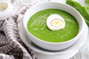 Bowl with delicious spinach soup on table