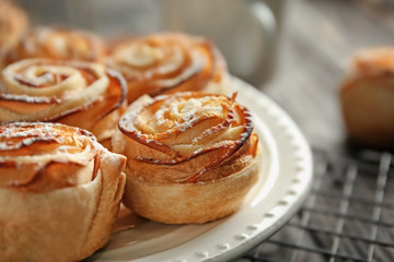 Plate with apple roses from puff pastry on table, closeup