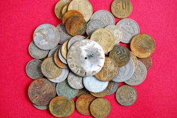 vintage clock on rusty coins on red background