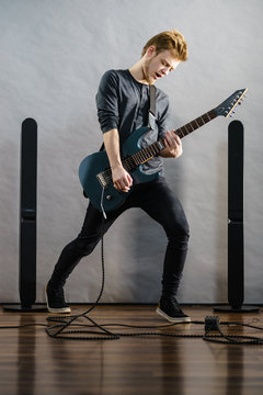 Young man playing electric guitar