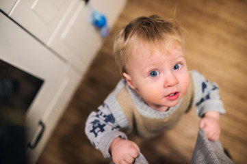 Fototapeta premium Top view of a toddler boy looking up at home. Close up.