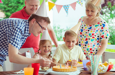 Colorful portrait of happy family celebrate birthday and grandparents blows candles with children