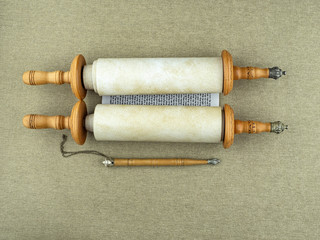 A Torah scroll with a pointer on the canvas.