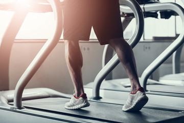 Close up. Man in Sneakers on Treadmill in Gym.