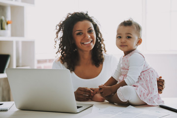 Young Smiling Freelancer with Daughter at Home.