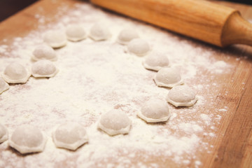 Fototapeta na wymiar flour and dumplings on wooden board