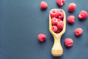 Fresh organic raspberries on black background. berries on a wooden spoon