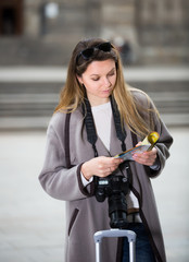 Blond smiling woman holding brochure in hands