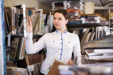 Cheerful woman is standing with modern pictures