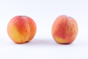 Peaches on a white background, two peaches isolated, orange nectarine close-up, blank for a designer, vegetarian food for breakfast, orange fruit for juice