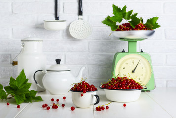 Red currant berries in a cup and bowl on the kitchen table