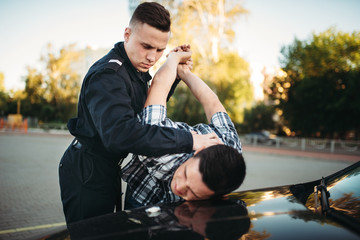 Policeman arrests the car thief on road