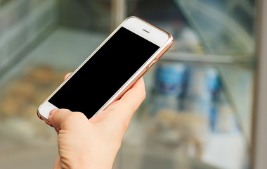 Girl holding smartphone, street light is a day, blurred background