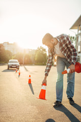 Instructor sets the cone, driving school concept