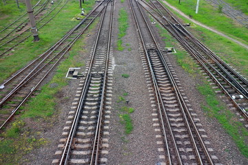 Fototapeta na wymiar Railway, the top view on rails. Leading parallel steel rails with regular crossbars. Abstract geometric view.