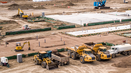 Aerial View Dump Trucks, Pailloader, Mini Excavator, High Hoe on busy job site, building foundation