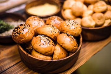 Buns with sesame seeds in a wooden plate