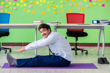 Man in the office with many conflicting priorities doing exercis