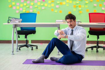 Man in the office with many conflicting priorities doing exercis