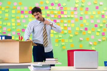 Man collecting his stuff after redundancy in the office with man